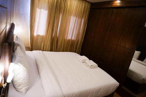 a bedroom with a white bed with two towels on it at The Expert in Ocean Blue Near Airport in Cairo