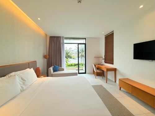 a hotel room with a bed and a television at Villa 3BR Beach Front in Cam Lâm