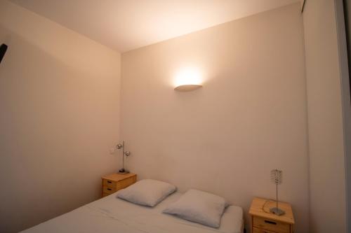 - une chambre avec 2 lits et une lumière sur le mur dans l'établissement Résidence Aria Marina Plage, à Ajaccio