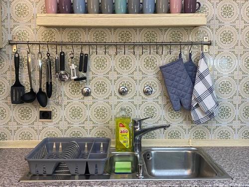 a kitchen sink with a dish drying rack and utensils at 150 m 5-room Villa 15 min to Düsseldorf in Kaarst