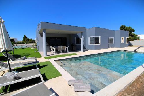 a large swimming pool in front of a house at Ca Na Elena Ibiza in Sant Josep de Sa Talaia