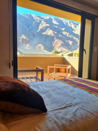 a bedroom with a large window with a mountain view at Hotel y Restaurante Winu Maimara in Maimará
