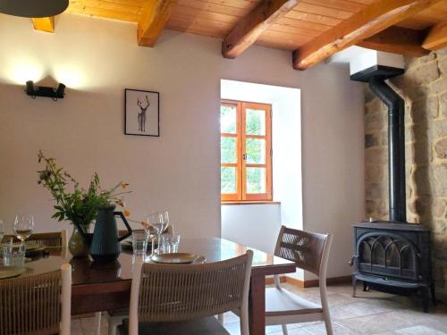 - une salle à manger avec une table et un poêle à bois dans l'établissement Charmante Maison en Pierres Sud Ardèche, à Saint-André-Lachamp