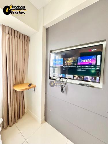 un téléviseur à écran plat accroché au mur dans l'établissement Good Life Luxury Condo, à Sampong