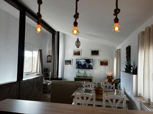 a dining room and living room with a table and chairs at Alojamiento Turístico Mirador del Castillo in Bedmar