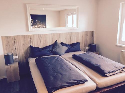 een slaapkamer met 2 bedden met blauwe kussens en een spiegel bij Die 19 in Kappel-Grafenhausen