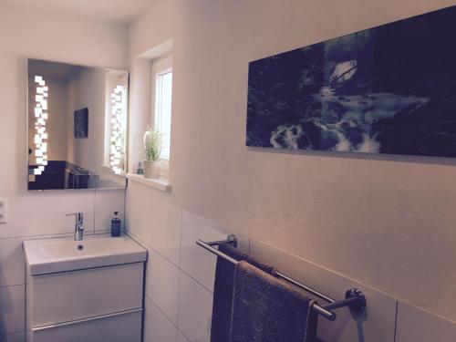 een witte badkamer met een wastafel en een spiegel bij Die 19 in Kappel-Grafenhausen