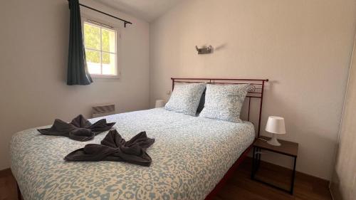 une chambre avec un lit avec deux chaussures dessus dans l'établissement La villa De Lina 202 -Self Check In, à Gallargues-le-Montueux