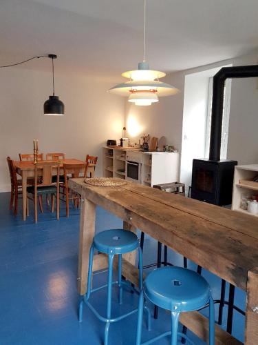 - une cuisine et une salle à manger avec une table en bois et des tabourets dans l'établissement Maison Vigneronne Typique, à Ménétréol-sous-Sancerre
