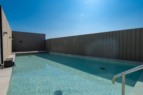 a swimming pool with blue water in a building at Aquaignis Awaji Island TRAILER PARK in Awaji