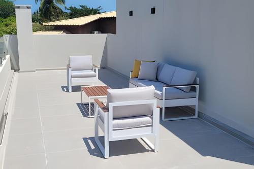 two chairs and a couch on a patio at Casa Praia de Sonho Verde condomínio fechado in Paripueira