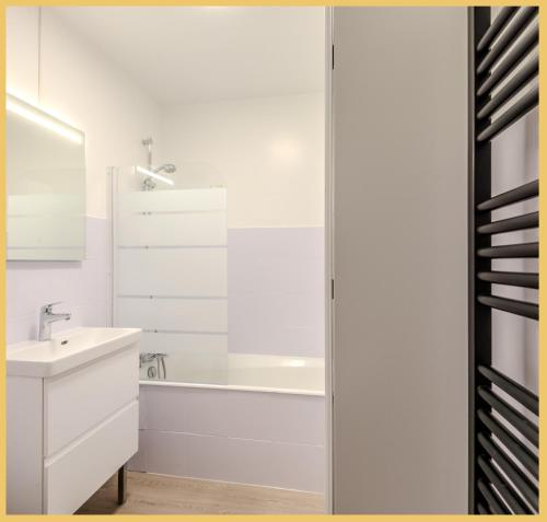 a white bathroom with a sink and a shower at Le Cyclade I Studio I Saint-Julien in Saint-Julien-en-Genevois