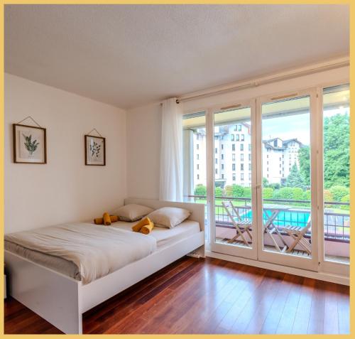 a bedroom with a bed and a balcony at Le Cyclade I Studio I Saint-Julien in Saint-Julien-en-Genevois