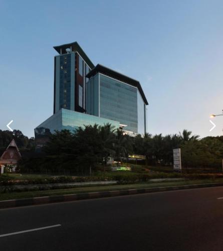 a large glass building in front of a road at Panbil Residence Apartment with Netflix, Gym and Pool in Kangboi