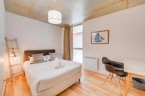 ein Schlafzimmer mit einem Bett, einem Schreibtisch und einem Stuhl in der Unterkunft Le Faubourg - Duplex pour 4 personnes à Bordeaux in Bordeaux