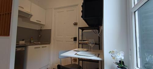 - une petite cuisine avec une table et un verre de vin dans l'établissement Suite Shànghǎi Huā - HyperCentre Rennes - 2 personnes - Second Lodge, à Rennes