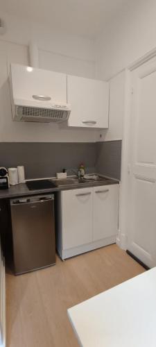 une cuisine avec des armoires blanches et un comptoir dans l'établissement Suite Shànghǎi Huā - HyperCentre Rennes - 2 personnes - Second Lodge, à Rennes