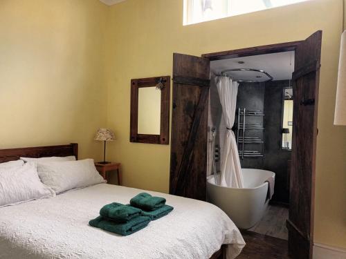 a bedroom with a large bed and a bath tub at Room with luxury private bathroom and independent entrance near Tube in London