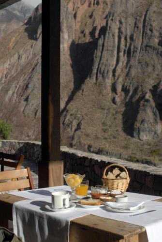 a table with food on it with a view of a mountain at Hotel Iruya in Iruya