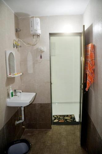 a small bathroom with a sink and a shower at Appa's Rain Hill Villa in Thane