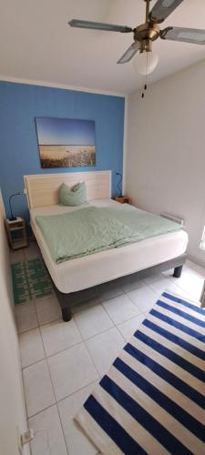 une chambre avec un lit avec un mur bleu dans l'établissement vacances plein sud, à Narbonne-Plage