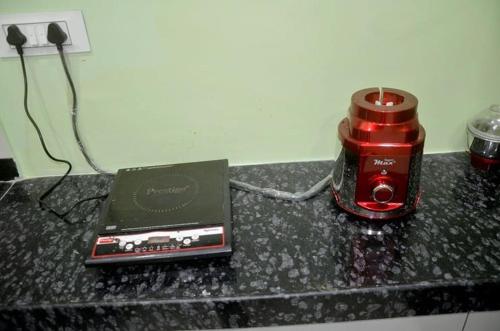 a black counter with a red blender and a laptop at Appa's Rain Hill Villa in Thane
