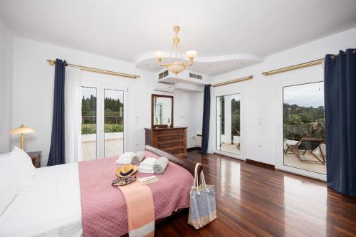 a bedroom with a large bed with a pink blanket at Villa Noulia in Kynopiástai
