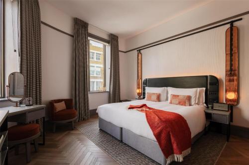 a hotel room with a large bed and a desk at Hart Shoreditch Hotel London, Curio Collection by Hilton in London
