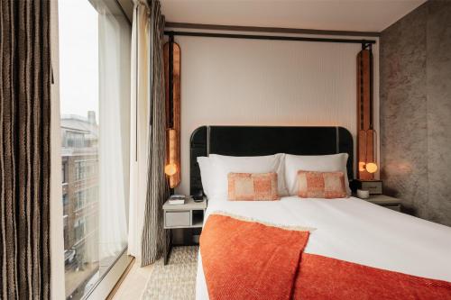 a bedroom with a bed and a large window at Hart Shoreditch Hotel London, Curio Collection by Hilton in London