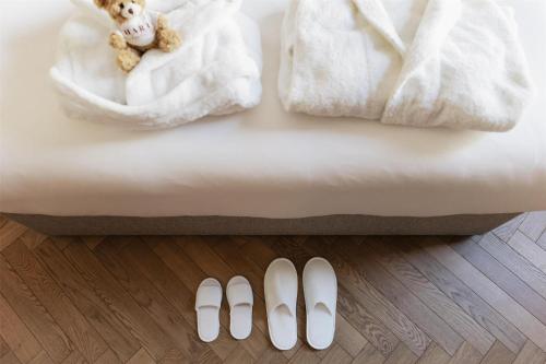 a bed with a teddy bear and two pairs of shoes at Hart Shoreditch Hotel London, Curio Collection by Hilton in London