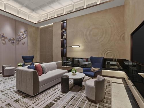 a living room with a couch and a table and chairs at Hilton Shanghai Greater Hongqiao in Shanghai