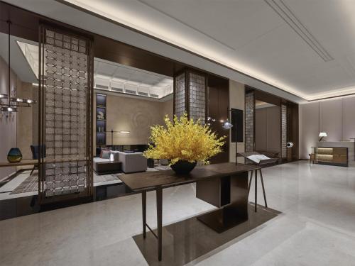 a lobby with a table with a vase of flowers on it at Hilton Shanghai Greater Hongqiao in Shanghai