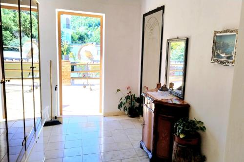 a hallway with a mirror and a door leading to a yard at Casa Lucia in Casamicciola Terme