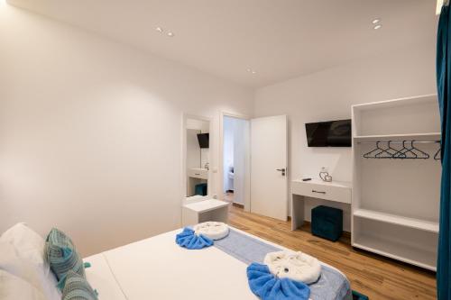 a white bedroom with a bed and a desk at Vila ZOGAJ in Ksamil