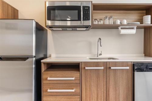 a kitchen with a stainless steel refrigerator and a microwave at Home2 Suites By Hilton Bozeman Four Corners in Bozeman