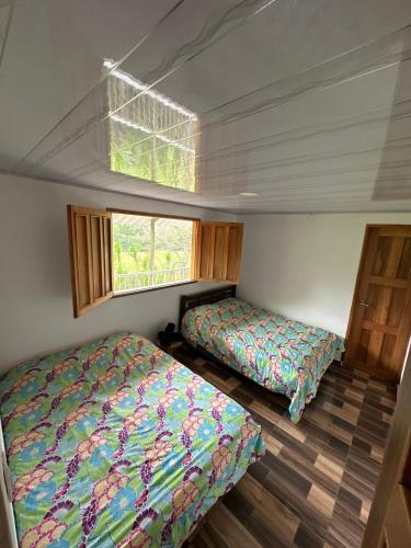a bedroom with two beds and a window at Paisaje Andino Salento in Salento