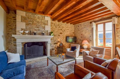 a living room with a fireplace and a blue couch at Domaine d'Essendiéras in Saint-Médard-dʼExcideuil