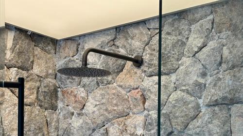 a stone wall with a shower in a bathroom at Agnadema Apartments in Firostefani