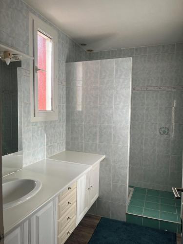 une salle de bain avec un lavabo blanc et une douche dans l'établissement Cosy House Collioure, à Collioure