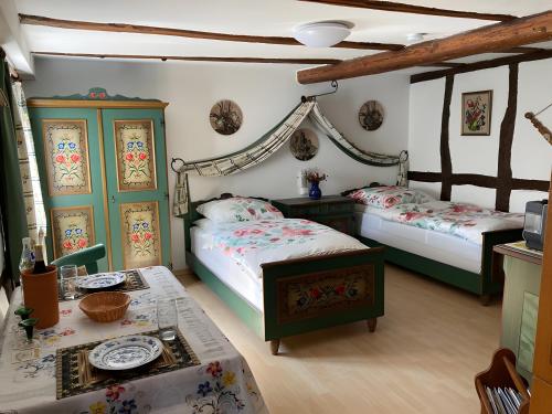 a bedroom with two beds and a table in it at Landgasthof und Landhaus Hofmeister in Diemelsee