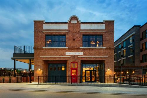 a brick building with a red door on a street at The Nobleman Fort Worth, Tapestry Collection By Hilton in Fort Worth