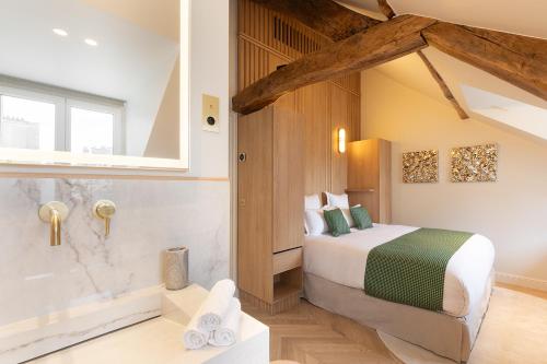 une chambre avec un lit et une baignoire dans l'établissement Maison Galante's apartments with Services in Louvre - Rue des Déchargeurs, à Paris
