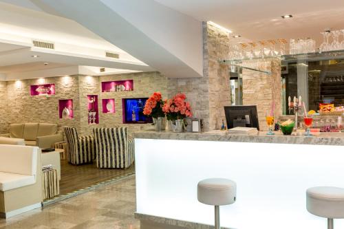 a lobby with a bar with chairs and tables at Hotel Rivamare in Lido di Jesolo