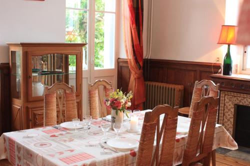 une salle à manger avec une table et des chaises avec des fleurs dessus dans l'établissement Villa Margalideto, à Saint-Gaudens