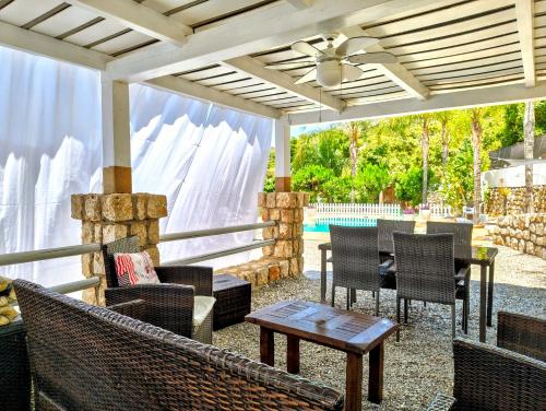 un patio con sillas, mesa y techo en Casa Rural Caserío Las Viñas, en Guájar Fondón