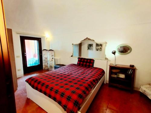 a bedroom with a bed with a plaid blanket at Casa Luciana in Chiaverano