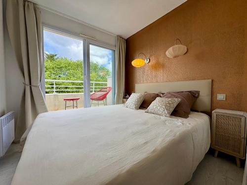 a bedroom with a large bed and a large window at La Baule terrasse, piscine, parking tout confort in La Baule