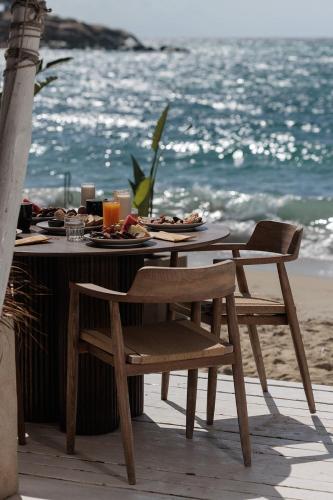 a table with plates of food on the beach at Anemomilos Beach hotel in Agia Anna Naxos
