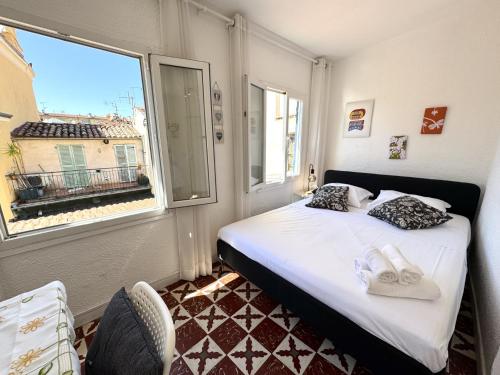 une petite chambre avec un lit et une fenêtre dans l'établissement ApartHotel Riviera - LES TOITS D AUGUSTIN - Bright Studio with A C - Old town, à Nice