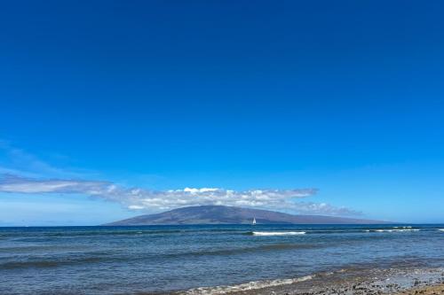 a mountain in the middle of the ocean with a beach at Puamana 30-2 in Lahaina